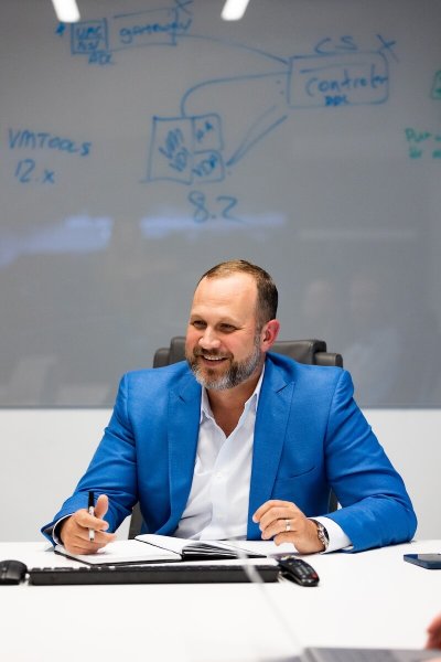 CEO of IT Services Company Greg Zolkos photo at meeting table